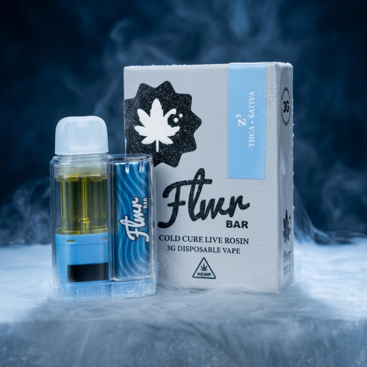 A Flwr Bar disposable vape device with blue and clear sections next to its white packaging box, set against a smoky blue background.
